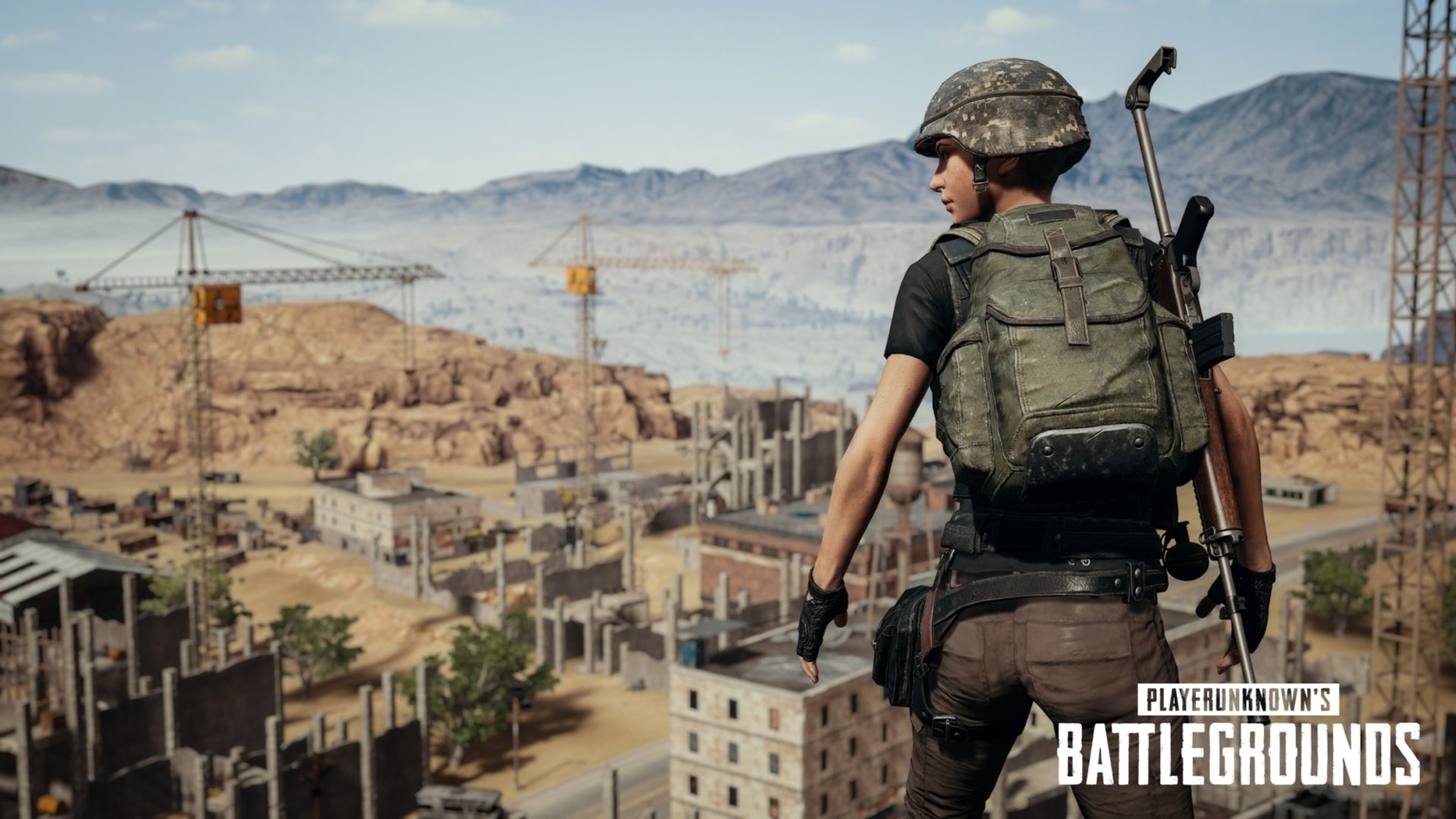 A PlayerUnknown's Battlegrounds player stands ready in a desert cityscape, fully geared with a backpack and weapons. High-definition desktop wallpaper.