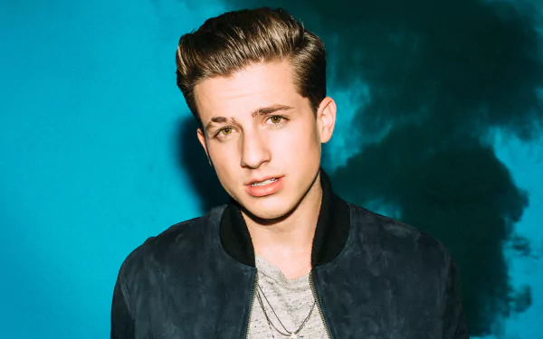 HD desktop wallpaper featuring a portrait of Charlie Puth against a blue, smoky background.