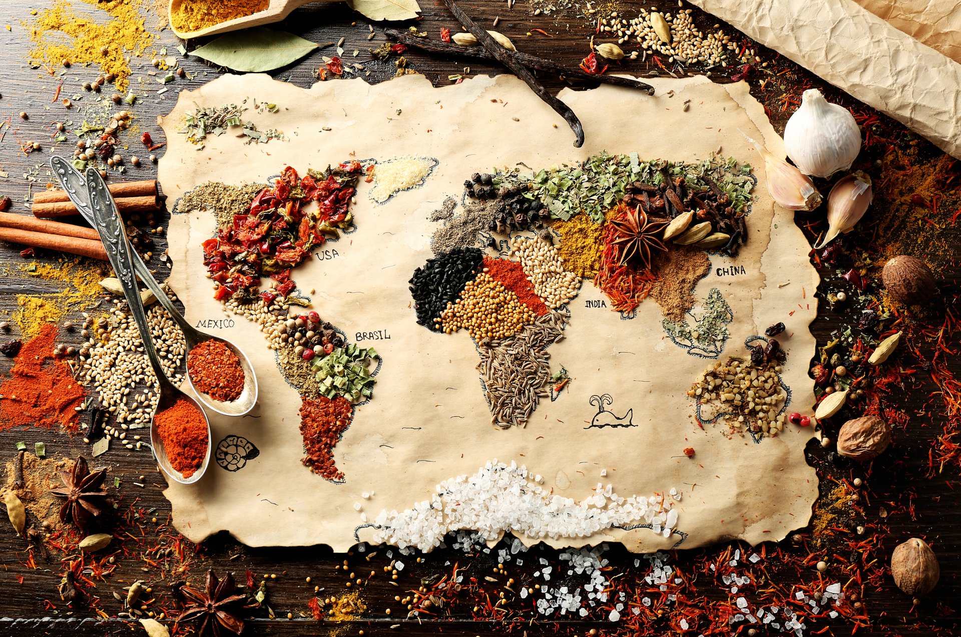 HD desktop wallpaper featuring an artistic map of the world composed of various spices and herbs, set on a rustic wooden background. Each continent is creatively represented with an array of colorful spices.