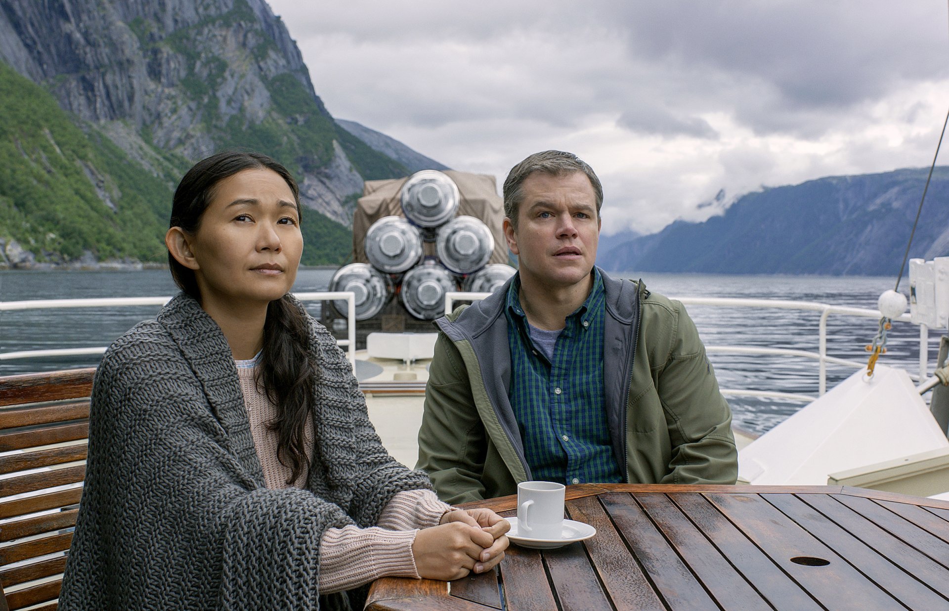 HD desktop wallpaper featuring Matt Damon and Hong Chau in Downsizing, with a scenic mountainous backdrop.