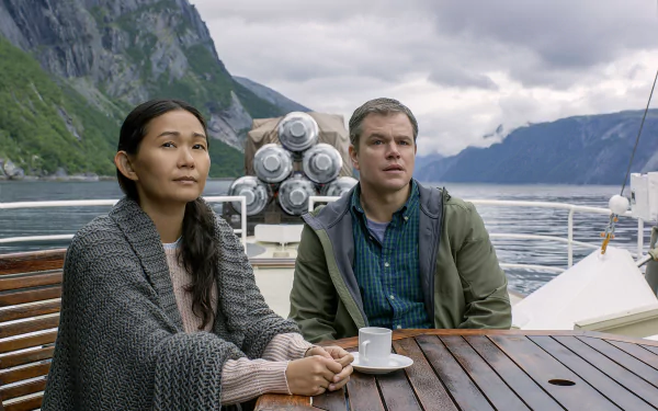HD desktop wallpaper featuring Matt Damon and Hong Chau in Downsizing, with a scenic mountainous backdrop.