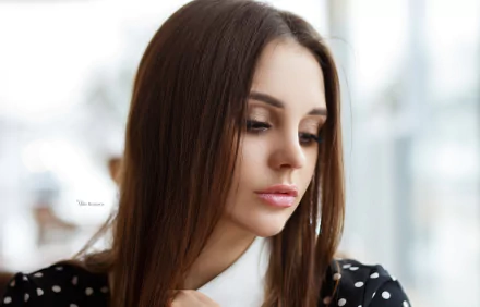 Brunette woman and model with long hair wearing lipstick, gazing downward in a soft-lit portrait — 2K Quad HD PC desktop wallpaper background.