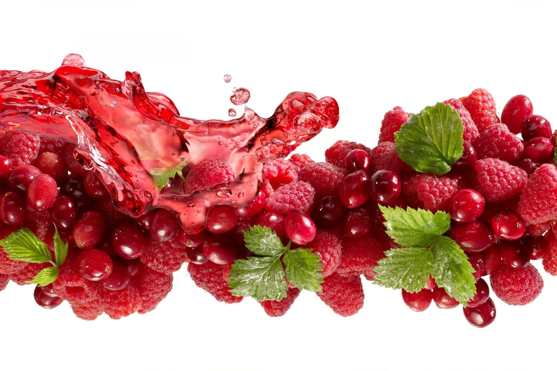 Vivid HD desktop wallpaper featuring fresh raspberries and cranberries with green leaves, highlighted by a splash of water, emphasizing vibrant red fruit and natural freshness.