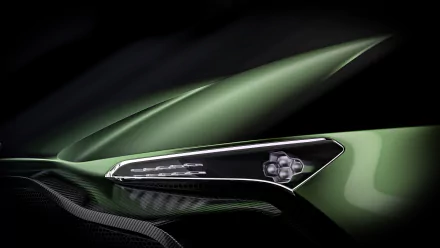 Close-up of the sleek side mirror of a green Aston Martin Vulcan hypercar, showcased as a 4K Ultra HD race car wallpaper and background.