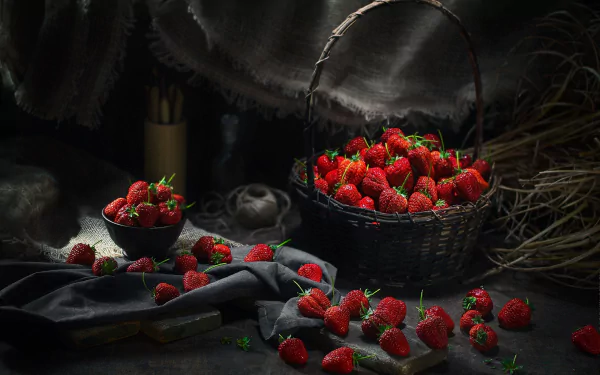 HD still life desktop wallpaper featuring a basket and bowl filled with fresh strawberries, scattered fruit, and a dark, moody background for a rich visual impact.