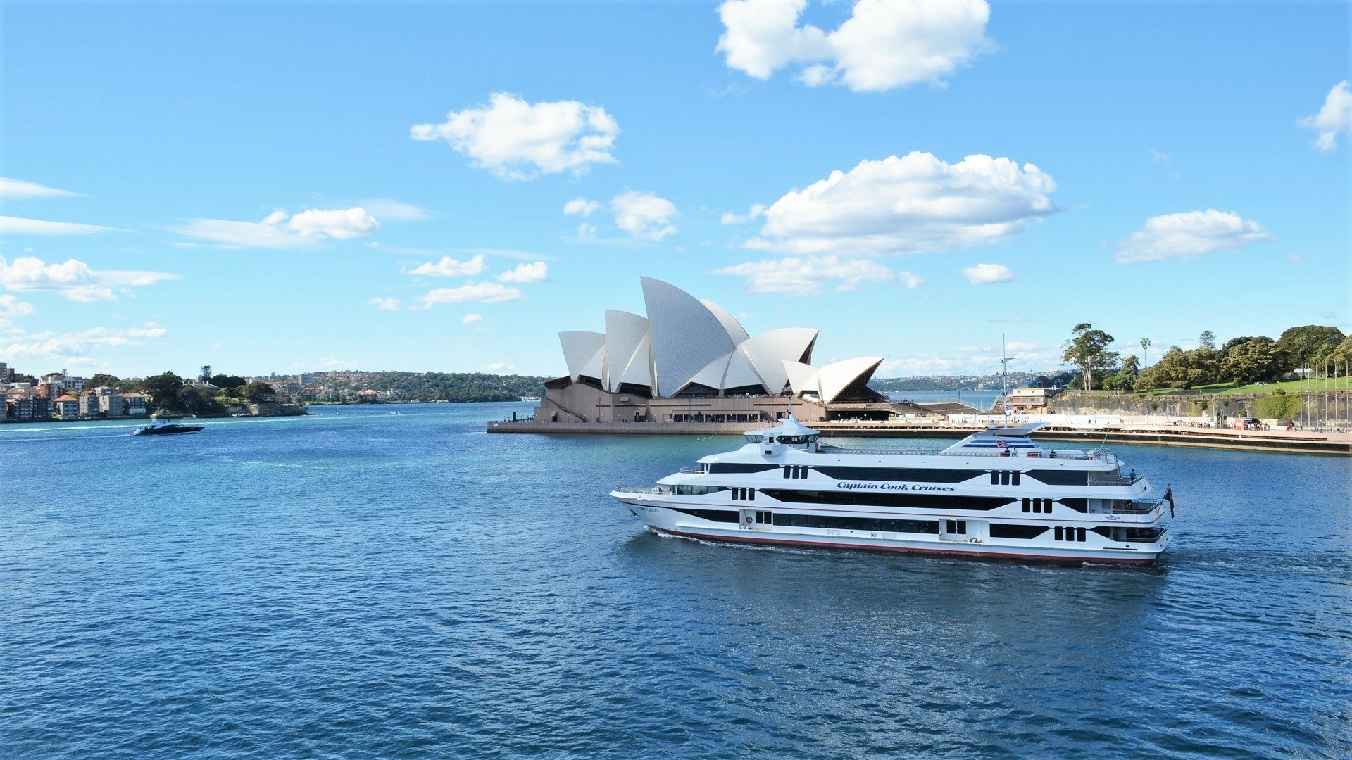 HD desktop wallpaper of Sydney Harbour featuring the iconic Sydney Opera House, a ferry cruising the water, and clear blue skies over Sydney, Australia.