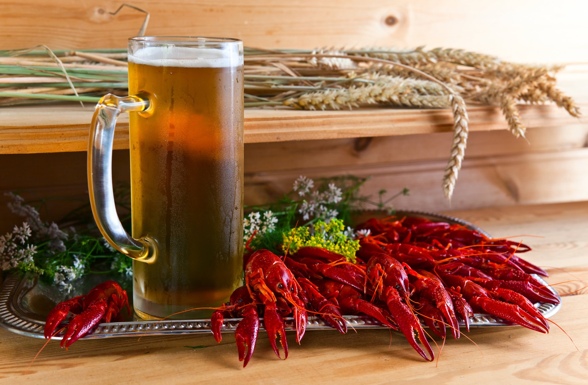 A 4K Ultra HD wallpaper featuring a glass of beer alongside a spread of bright red crustaceans and herbs on a wooden surface, evoking seafood and drink themes.