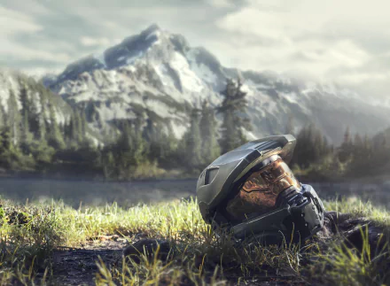 HD wallpaper featuring Master Chief's helmet from the video game Halo Infinite, set against a stunning mountainous landscape with lush greenery and a serene lake.