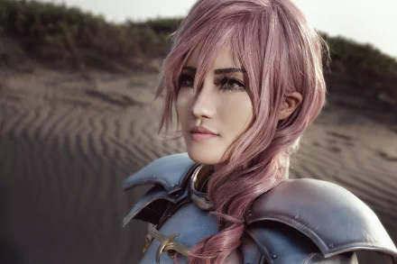 HD PC desktop wallpaper of a woman cosplay model with pink hair from Final Fantasy, wearing silver armor and gazing into the distance on a windswept dune.