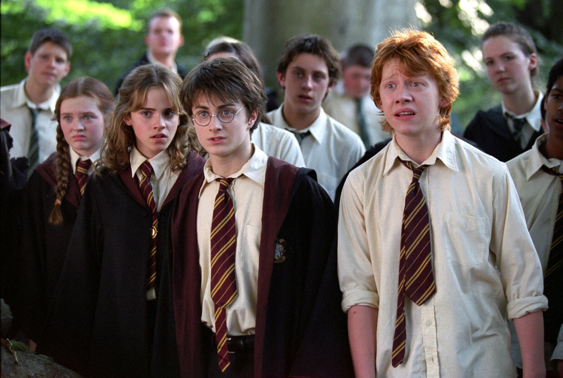 HD desktop wallpaper from the movie Harry Potter and the Prisoner of Azkaban featuring Ron Weasley, Harry Potter, and Hermione Granger with other students in Hogwarts uniforms.