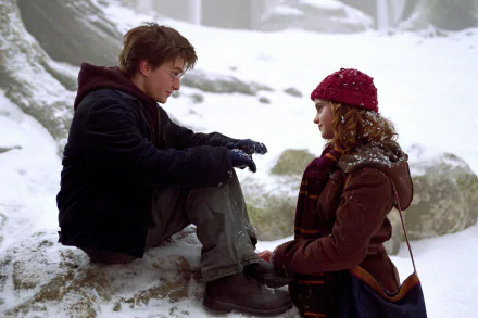 Harry Potter and Hermione Granger sit in a snowy forest scene from Harry Potter and the Prisoner of Azkaban, captured in an HD PC desktop wallpaper.