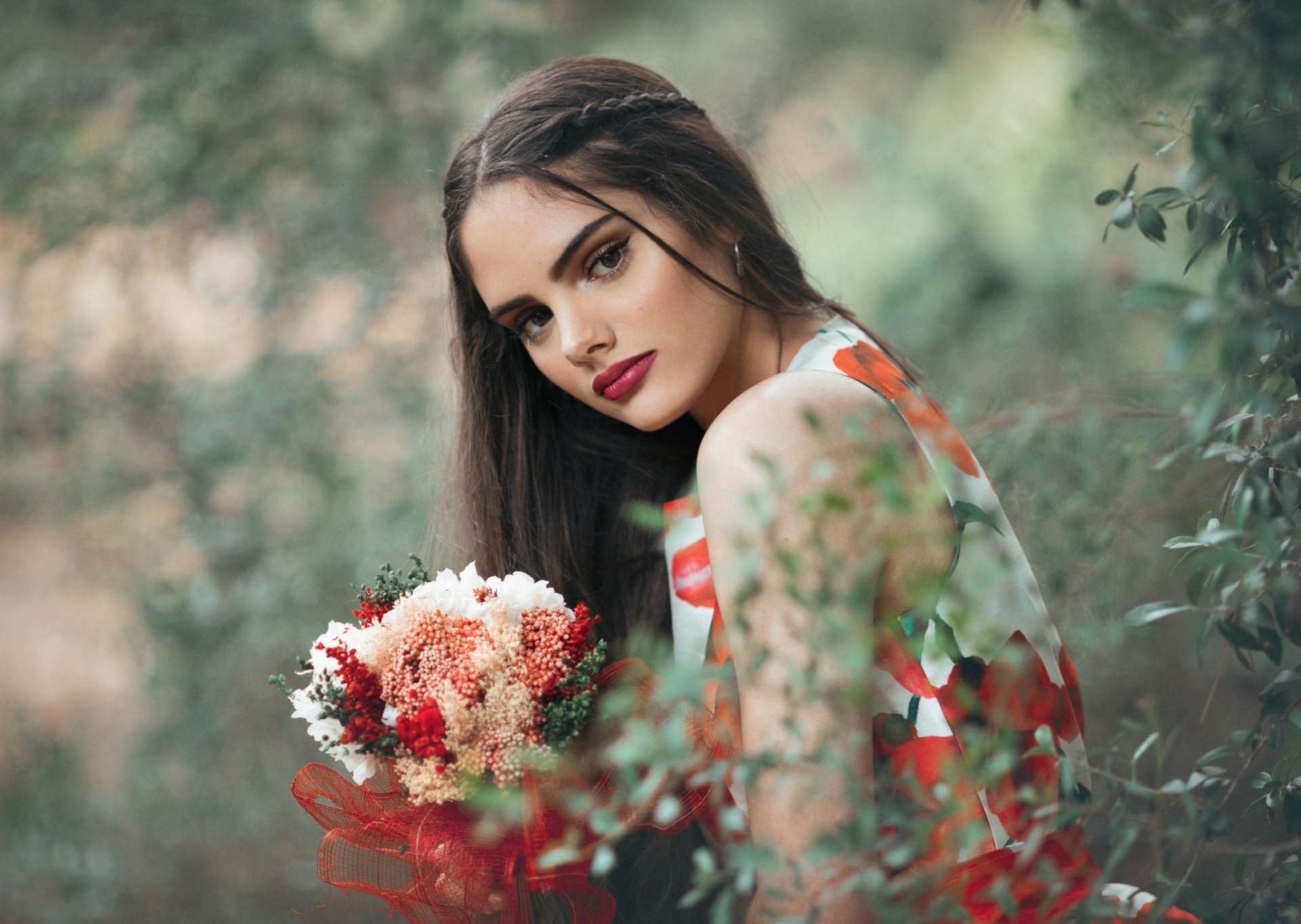 HD PC desktop wallpaper of a brunette model with brown eyes and red lipstick holding a bouquet, shallow depth-of-field background
