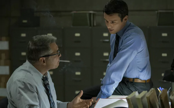 HD desktop wallpaper from 'Mindhunter' featuring two characters in a discussion inside an office with file cabinets.