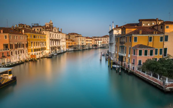 Panoramic view of Venice’s Grand Canal, Italy, showcasing historic buildings lining the man-made waterway under a clear sky in 4K Ultra HD quality.