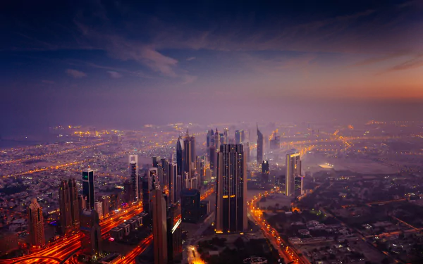 Nighttime cityscape of Dubai featuring the illuminated Burj Khalifa skyscraper against a dark sky, captured in 4K Ultra HD detail.