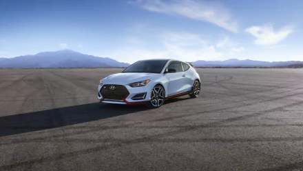 White Hyundai Veloster on open tarmac under a blue sky — 4K Ultra HD PC desktop wallpaper showing a sporty Hyundai vehicle.