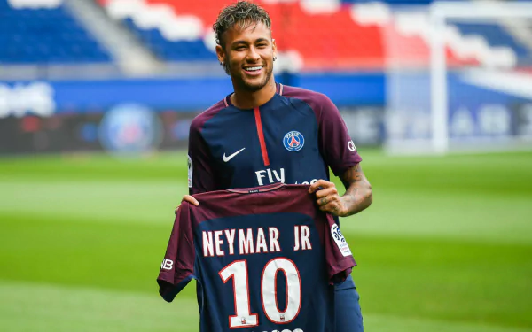 Brazilian soccer star Neymar Jr. holds his Paris Saint-Germain F.C. jersey with the number 10 in a vibrant HD desktop wallpaper background.