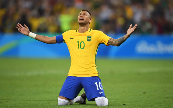 Brazilian soccer star Neymar kneels on the field, arms outstretched in celebration, captured in vibrant 4K Ultra HD quality.