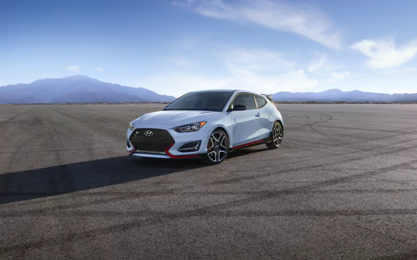 White Hyundai Veloster on open tarmac under a blue sky — 4K Ultra HD PC desktop wallpaper showing a sporty Hyundai vehicle.