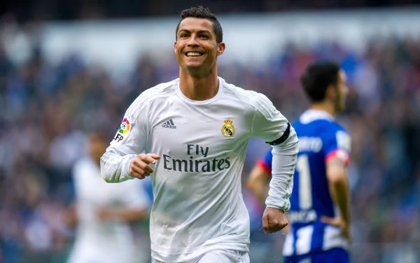 HD wallpaper of Portuguese soccer player Cristiano Ronaldo in a white Real Madrid jersey, smiling during a match. Other players and the crowd can be seen in the background.