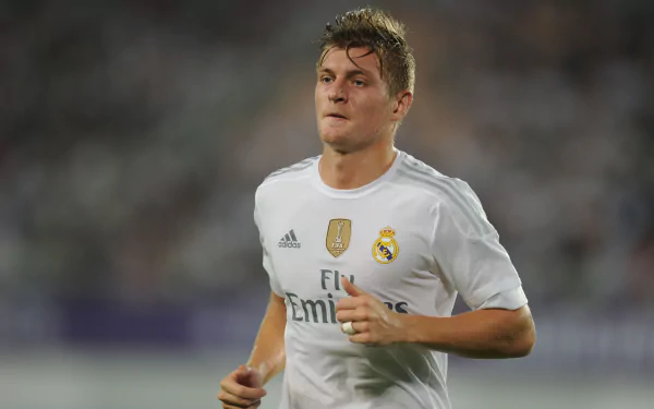 4K Ultra HD image of German soccer player Toni Kroos in a Real Madrid jersey during a match, capturing intense focus and athleticism in sports.