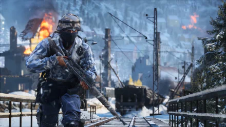 HD PC desktop wallpaper depicting a soldier in winter camouflage advancing on snow-covered railroad tracks from the video game Battlefield V.