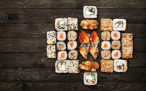 A vibrant assortment of sushi rolls with rice and seafood arranged on a dark wooden surface, captured in 4K Ultra HD for a crisp, detailed still life food wallpaper.
