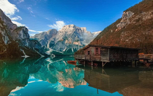 4K Ultra HD image of a serene mountain lake with crystal-clear reflections, featuring a rustic man-made boathouse along the water’s edge under a bright blue sky.