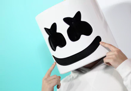 HD desktop wallpaper of Marshmello, the famous DJ, wearing his signature marshmallow helmet against a blue and white background.