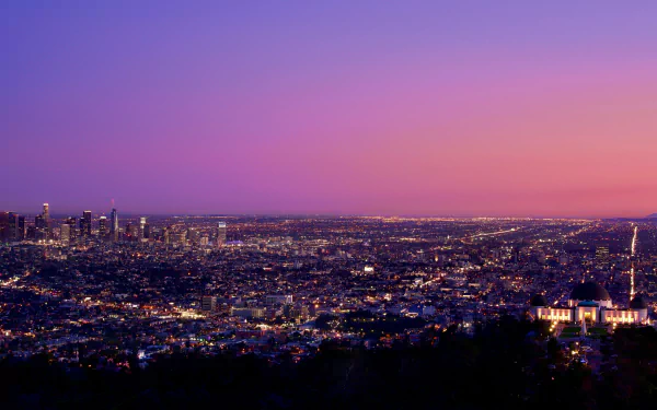 4K Ultra HD view of Los Angeles cityscape at dusk, showcasing skyscrapers and a vibrant horizon under a colorful sky.