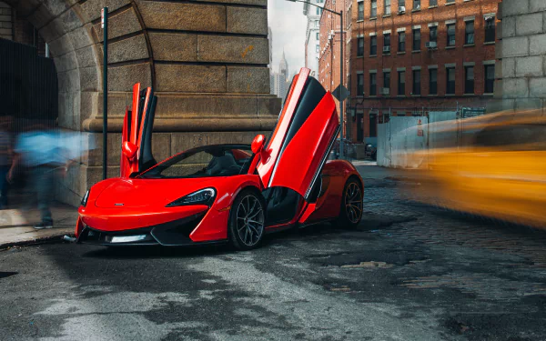 Red McLaren 570S Spider supercar vehicle with butterfly doors open on a wet city street, blurred traffic light trails — 5K Ultra HD PC desktop wallpaper and background.