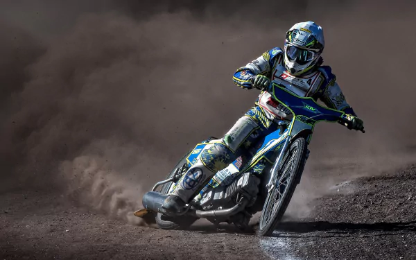 HD PC desktop wallpaper of a motocross rider on a motorcycle racing a dirt track, leaning into a turn and kicking up dust.