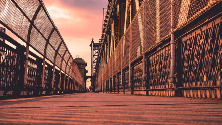 Low-angle sunset view of the man-made Manhattan Bridge in Manhattan, New York, showing the wooden walkway and steel railings — HD PC desktop wallpaper background.