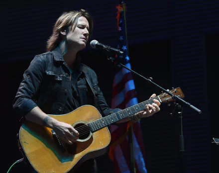 HD desktop wallpaper featuring a musician playing guitar with an American flag in the background.