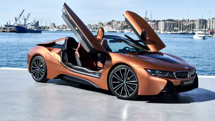 Orange BMW i8 supercar with scissor doors open, parked by a waterfront marina, showcased in 4K Ultra HD as a PC desktop wallpaper and background.