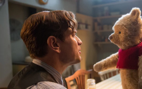 HD desktop wallpaper featuring Ewan McGregor as Christopher Robin in a heartwarming scene with Winnie the Pooh.