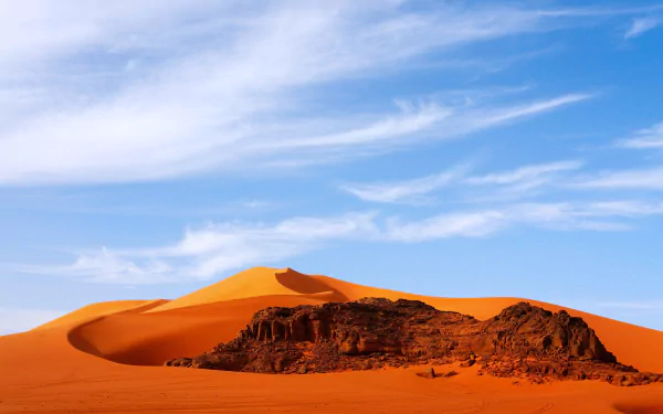 Sahara desert in Algeria, Africa: golden sand dunes and rocky outcrop beneath a blue sky — 4K Ultra HD PC desktop wallpaper/background, nature.