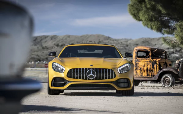 Yellow Mercedes-AMG GT R supercar front view parked in a dry landscape beside a rusted truck — 5K Ultra HD PC desktop wallpaper.