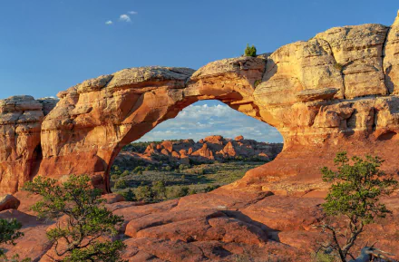 HD desktop wallpaper showcasing a stunning natural rock arch in Arches National Park, highlighting the vibrant landscape and clear blue sky.
