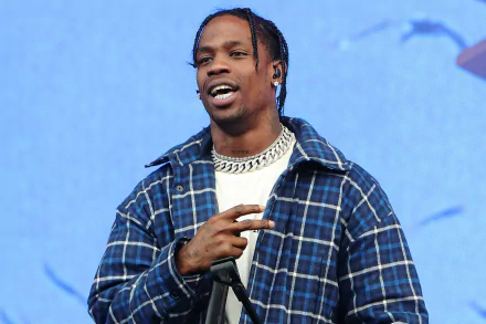 HD desktop wallpaper featuring a person on stage with a microphone, dressed in a plaid shirt, set against a blue backdrop.