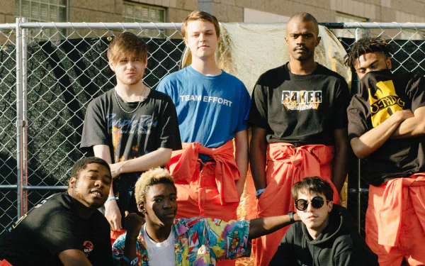 HD desktop wallpaper of Brockhampton group posing together in front of a chain-link fence.
