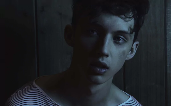 HD desktop wallpaper featuring a moody portrait of a person in striped attire against a dark background.