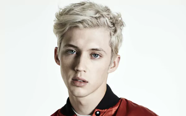 HD desktop wallpaper featuring a portrait of a person with platinum blonde hair and blue eyes, wearing a red and black shirt.