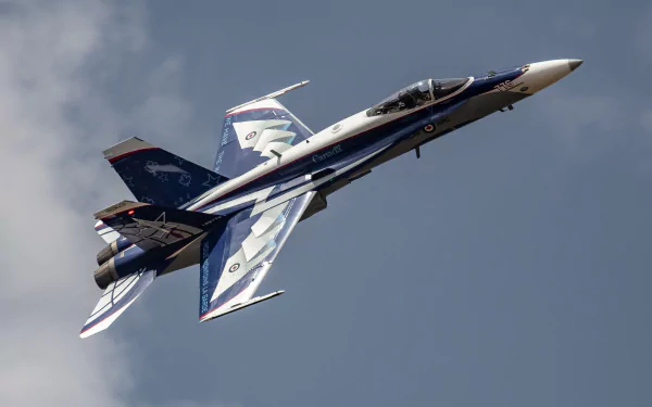 HD wallpaper of a McDonnell Douglas CF-18 Hornet jet fighter military aircraft soaring against a cloudy sky.