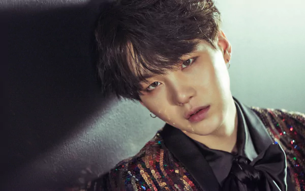 HD desktop wallpaper featuring Suga, a member of BTS, against a dark backdrop, showcasing his charismatic aura.