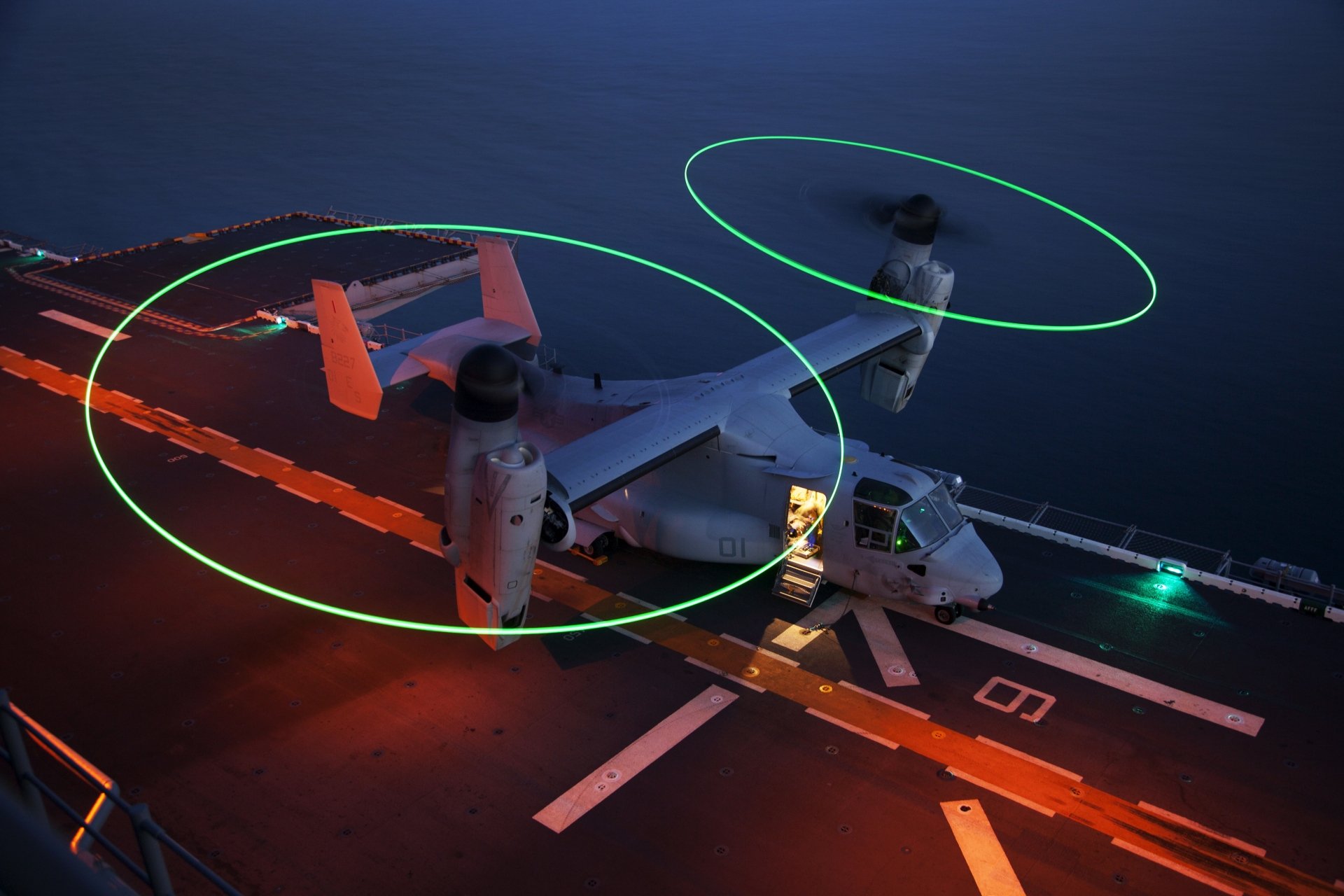 Bell Boeing V-22 Osprey transport aircraft and helicopter on a ship deck at night, captured in 4K Ultra HD for a military-themed desktop wallpaper.