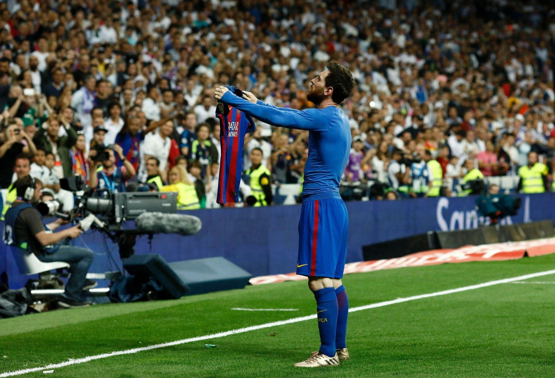 Lionel Messi celebrates passionately with a jersey in hand, surrounded by a vibrant crowd, capturing the spirit of sports in this HD desktop wallpaper.
