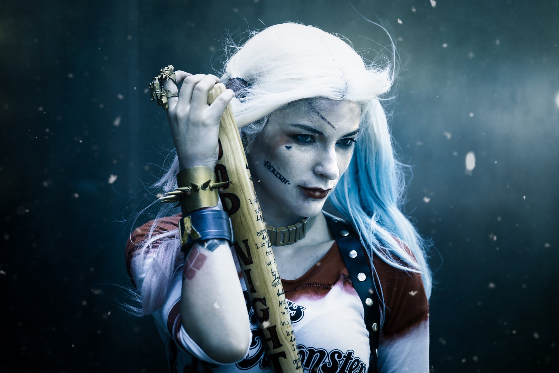 A 4K Ultra HD cosplay wallpaper of a woman dressed as Harley Quinn holding a baseball bat, with white and blue hair, lipstick, and the White House faintly visible in the background.