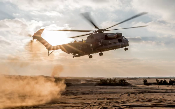HD desktop wallpaper showing a military Sikorsky CH-53 Sea Stallion helicopter flying low over a sandy terrain with dust clouds and a cloudy sky backdrop.