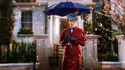 Emily Blunt as Mary Poppins in a red outfit holding a blue umbrella, standing in front of a house with petals falling around her, captured in 8K Ultra HD movie wallpaper.